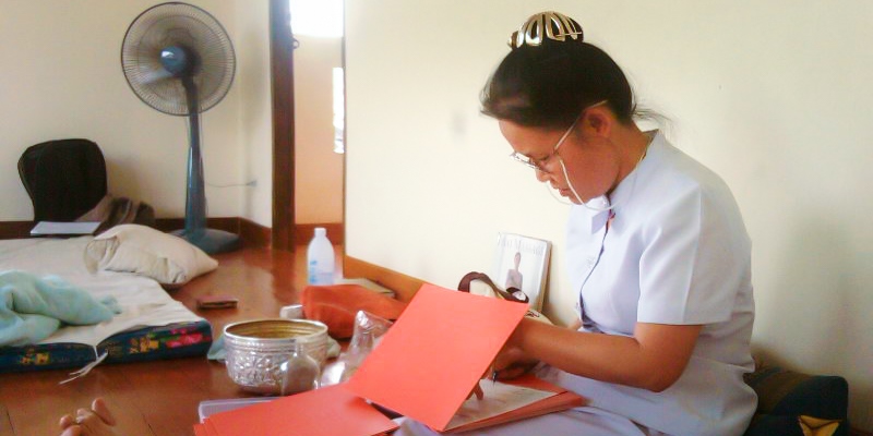 Teacher Dot Po signing Thai Massage Completion certificates at the Sunshine Massage School