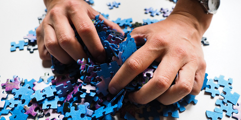Hands mixing puzzle pieces