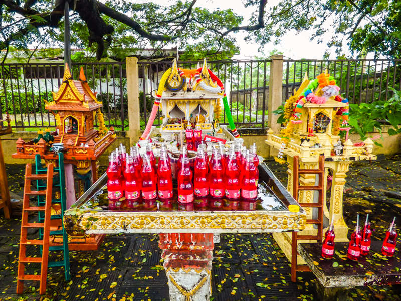 Spirit houses with lots of strawberry Fanta offerings in Hat Yai, Thailand.