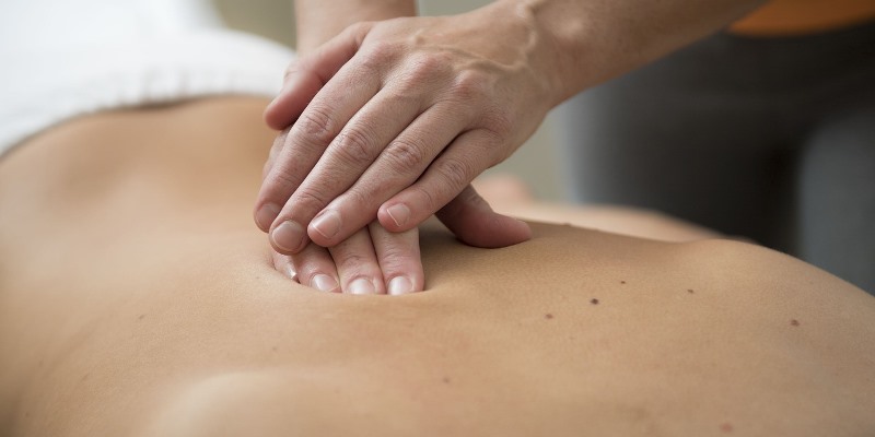 Therapist giving massage to patient