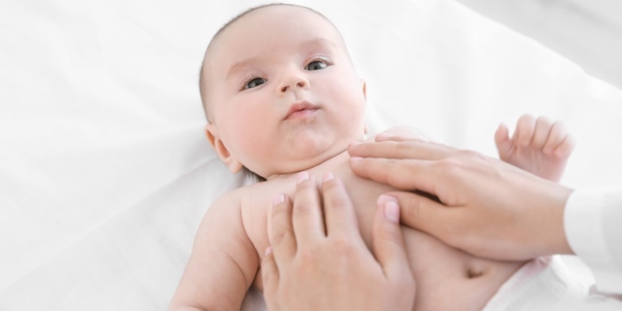 Mother massaging baby