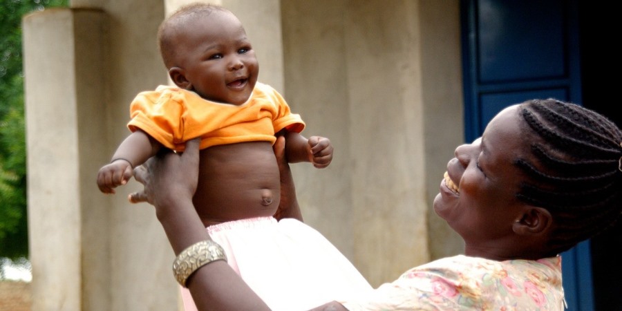 Mother lifting laughing baby in the air