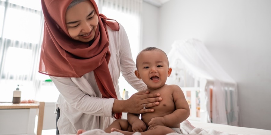 Mother giving massage to baby