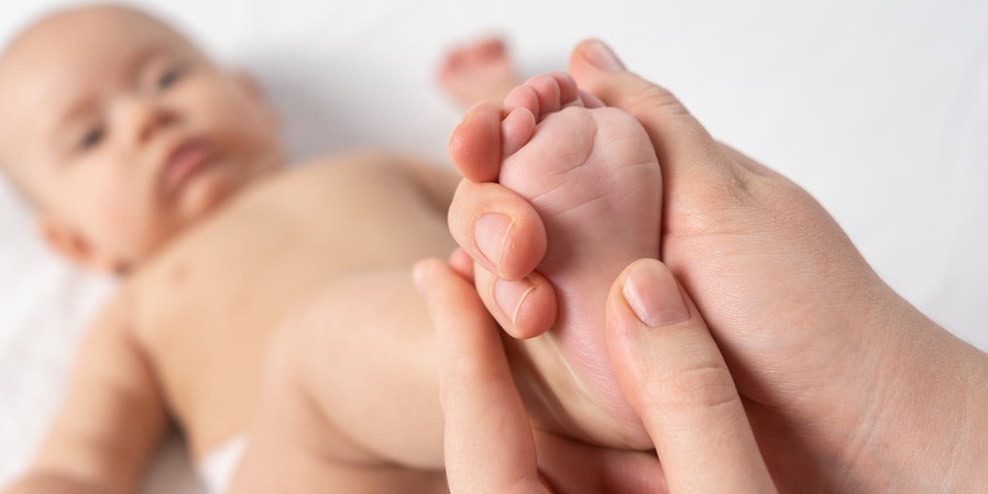 Mother giving baby a foot massage