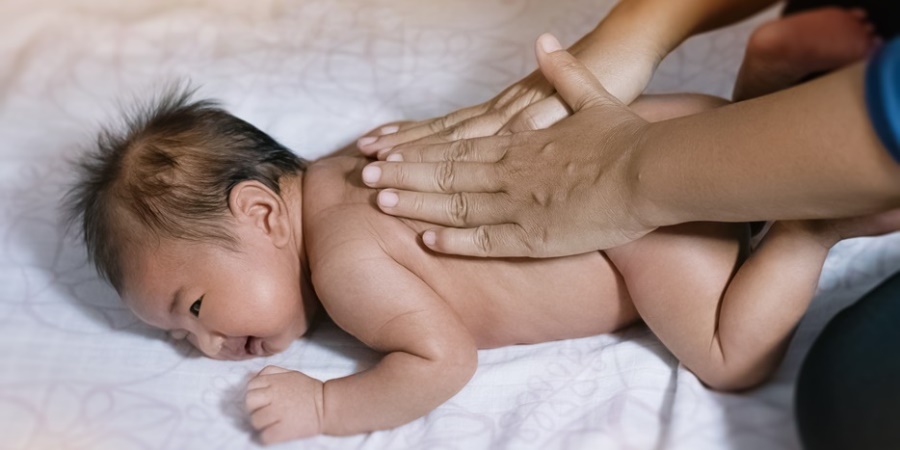 Mother giving massage to baby