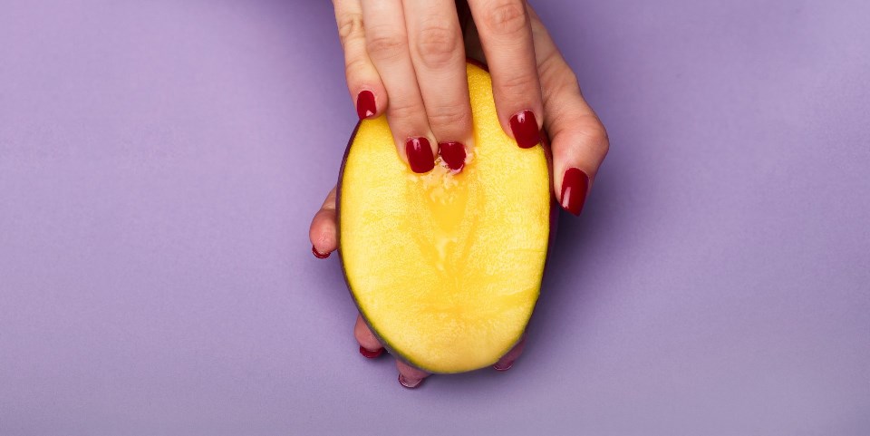 Female fingers touching peach
