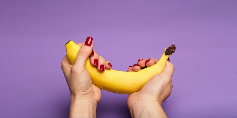 Woman holding banana with hands