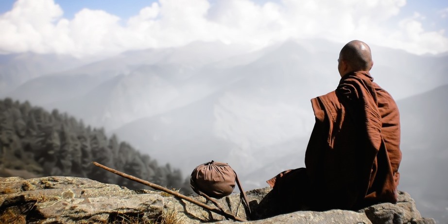 Monk meditating in the mountains