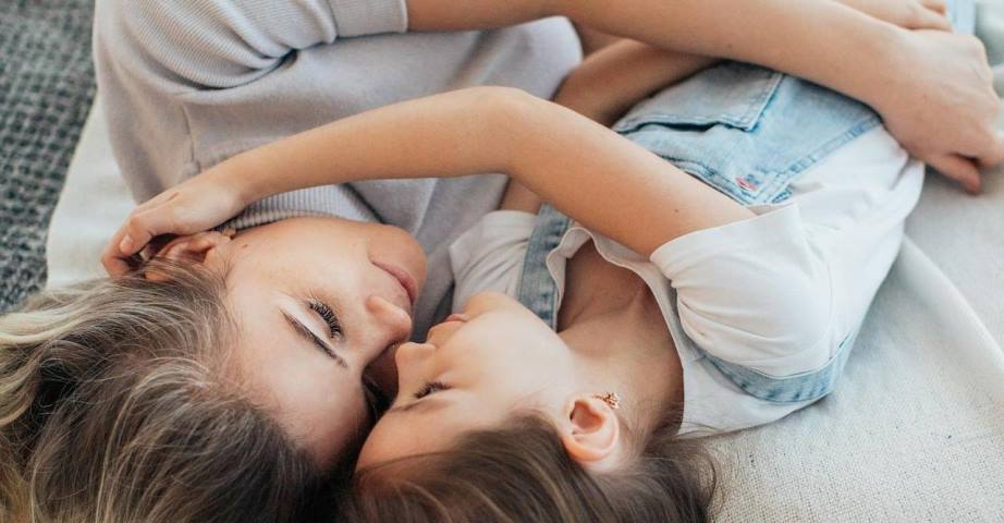 two women cuddling in bed