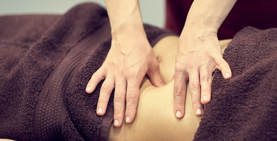 Woman receiving abdominal massage therapy