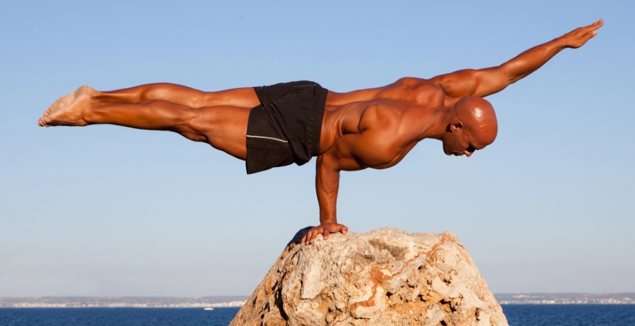 Strong man balancing on one hand