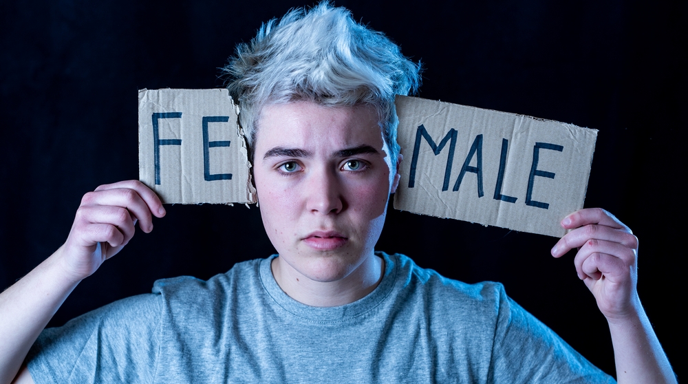 Transgender holding ripped fe-male sign near the head