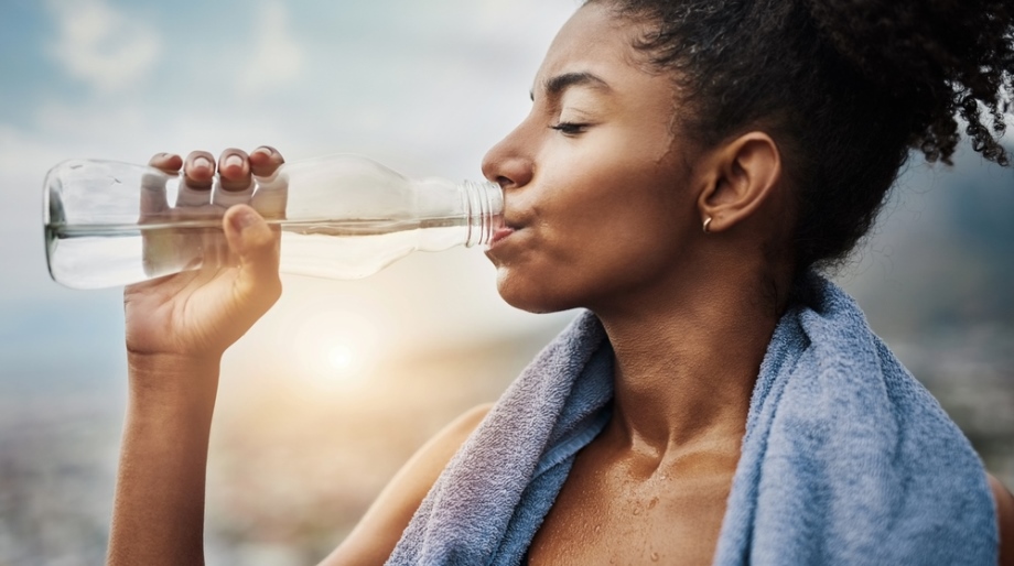 Woman drinking water after physical exercise