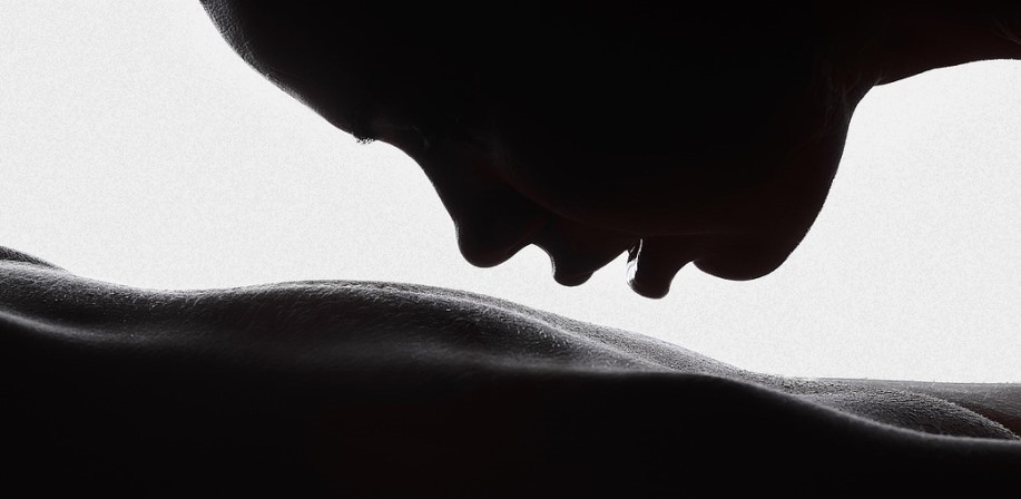 Woman sensually kissing nude body