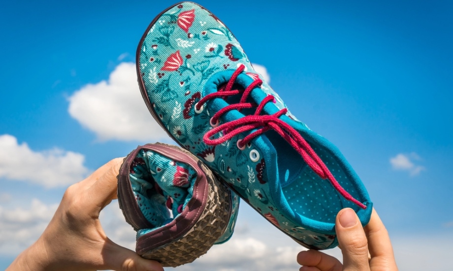 Man holding barefoot shoes in hands