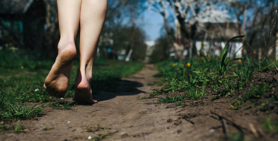 Risks and Health Benefits of Barefoot Walking Woman walking barefoot on sand path